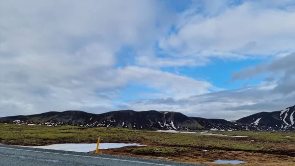 アイスランドの空のハイウェイ 凍った高地 氷がアイスランドの牧草地を覆ったアイスランドの景色を横切るだけの道 雪山トップス 長いロードコンセプトの壮大なノルディックな風景 — ストック写真