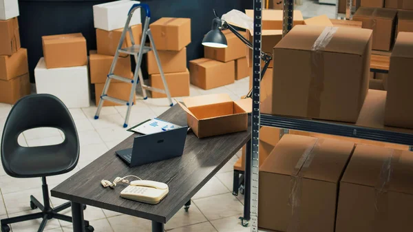 Small business warehouse filled with merchandise to ship to customers, products in cardboard packages used for startup development. Empty storage room space with carton boxes and supplies.