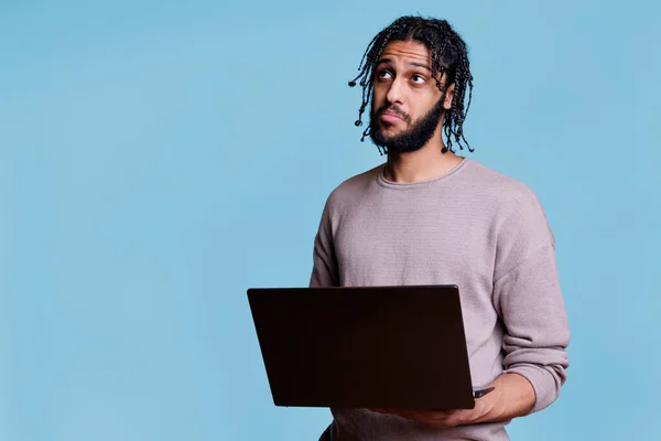 Pensivo Árabe Homem Pensando Sobre Relatório Negócios Enquanto Segurando Laptop — Fotografia de Stock