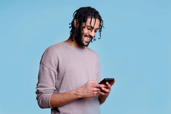 Glimlachende Arabische Man Sms Smartphone Met Vrolijke Gezichtsuitdrukking Vrolijke Jongere — Stockfoto