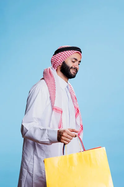 Glückliche Konsumenten Traditioneller Muslimischer Kleidung Tragen Eine Gelbe Einkaufstasche Lächelnde — Stockfoto