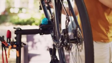 Motosiklet arka raydan çıkarıcı ve dişli takımının bakımı ve dinlenme bisikletleri için bahçede ayarlanması. Beyaz adam tarafından bisiklet parçalarının bakımına ilişkin ayrıntılı görüş ve test.