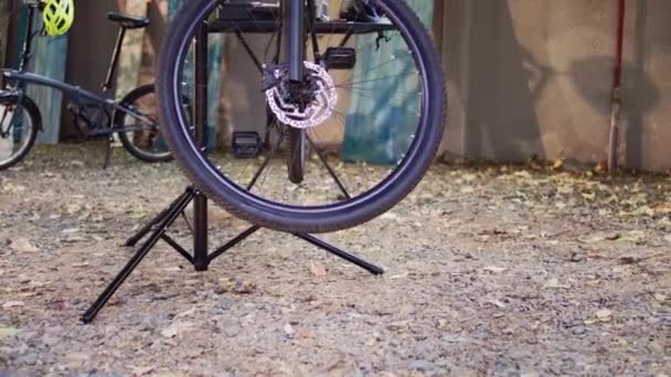 修理スタンドに取り付けられた破損した自転車の詳細なビューは 屋外ツールの品揃えで修理する準備ができています 毎年恒例の夏のアップキーピングと家庭菜園での近代的な自転車のサービス — ストック動画