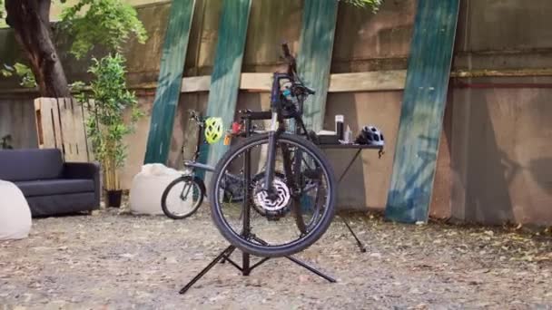 近代的な自転車は 毎年夏のメンテナンスに備えて裏庭に配置され 確保されました 修理スタンドで壊れた自転車の近くの外部プロのツールボックスのサイドビューショット — ストック動画