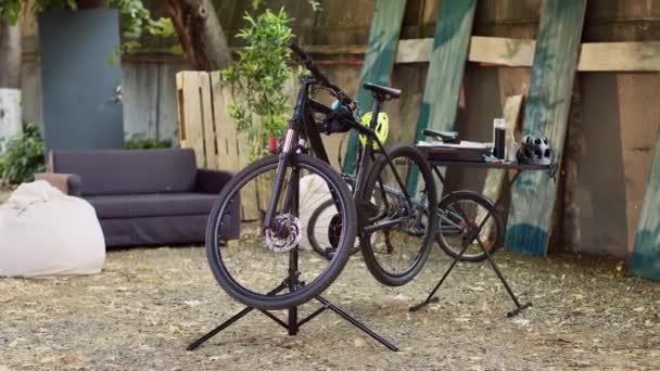 백그라운드에서 수리를위한 도구로 작업대에 부서진 자전거의 손상된 자전거는 기다리는 뒤뜰에서 — 비디오