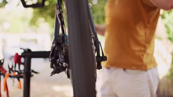 カセット プーリーホイール 後部脱線車など 外部に多数の自転車部品が供給されている 専門装置が付いている壊れた自転車の車輪を修理する人の細部 — ストック動画