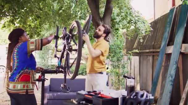 院子里积极喜爱运动的男朋友和女朋友用工具更换自行车轮胎 进行年度维修 健康的多族裔夫妇为户外自行车检查和修理自行车用具 — 图库视频影像