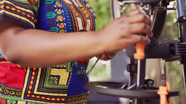 スポーツを愛するアフリカ系アメリカ人女性が自宅の庭で自転車のメンテナンスのための専門機器の品揃えを手配します 現代の自転車を修理するためのワークツールを準備する外の黒人女性 — ストック動画