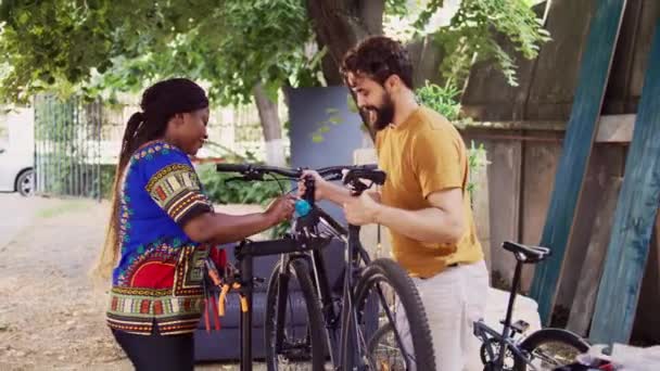Νεανικό Και Αθλητικό Διαφυλετικό Ζευγάρι Που Φτιάχνει Χαλασμένο Ποδήλατο Έξω — Αρχείο Βίντεο