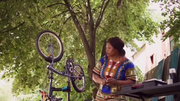 Sağlıklı Siyah Bir Kadın Bahçedeki Özel Ekipmanlarla Kendi Bisikletini Tamir — Stok video