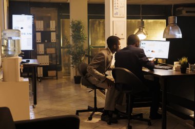 Şirket çalışanı finansal istatistikleri analiz ediyor, şirket yatırım stratejisini tartışıyor, şirket ofisinde fazla mesai yapıyor. Afrika kökenli Amerikalı işçiler yönetim fikirlerini tartışıyorlar. İş konsepti