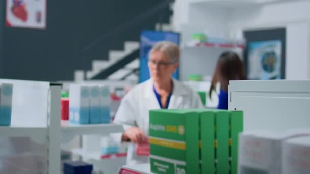 Farmacologista Experiente Envelhecido Dispensário Segurando Cesta Compras Organizando Mercadorias Prateleiras — Vídeo de Stock
