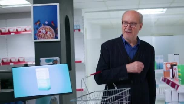 Отслеживание Камеры Которой Пожилой Человек Держащий Корзину Покупками Входит Аптеку — стоковое видео