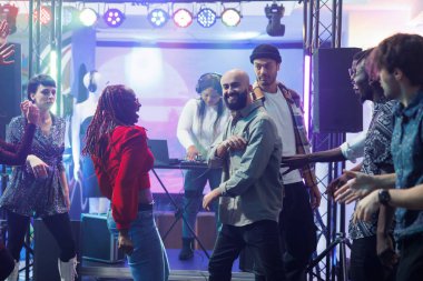 Neşeli çeşitli çiftler gece kulübü diskoteğinde doğaçlama dans savaşı yaparken gülüyorlar. Kalabalık dans pistinde dans eden ve gece kulüpte eğlenen kaygısız insanlar.