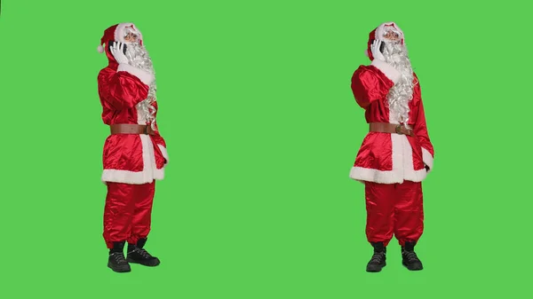圣尼克在演播室接听电话 使用智能手机移动电话线路进行远距离交谈 圣诞人物在全身上下绿屏下与人交谈 — 图库照片