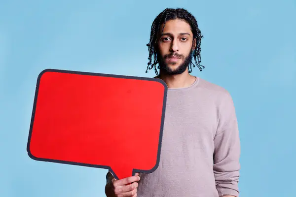 阿拉伯男子举着红色的空横幅 上面有文字 用来做广告 制作模型和观看相机 带有空白对话框的模型 用于带有复制空间肖像的消息 — 图库照片