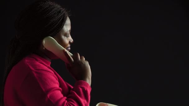 Молодая Женщина Разговаривает Кабельному Телефону Изолированном Черном Фоне Портрет Африканской — стоковое видео