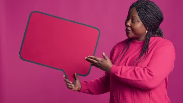 アフリカ系アメリカ人の美しさは テキストメッセージやメモのために右手に赤いスピーチバブルのモックアップを把握します バブルコピースペーステンプレートの情報の承認を示す黒人女性 — ストック動画