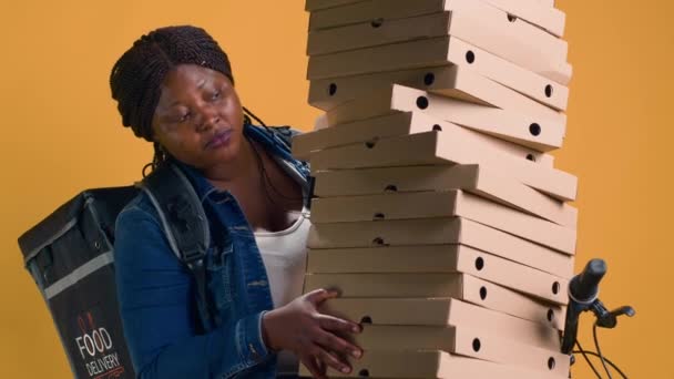 非裔美国人送货时 平衡了大量的披萨盒 可以送到邻居家 活跃的黑人妇女骑自行车小心搬运大宗食品 — 图库视频影像