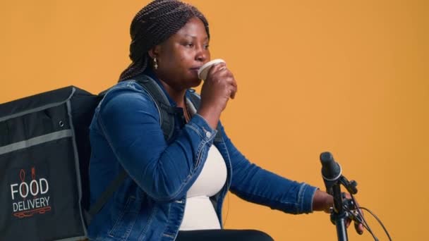 Elinde Kahveyle Mahallede Bisiklet Süren Aktif Siyahi Bir Kadının Teslimatı — Stok video
