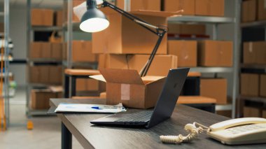 Depolarında bir yığın eşya ve malzeme olan boş bir depo, raflar ve raflar dolusu ürün var. Depo eskiden lojistik alanında çalışan müşterilere mal dağıtıyordu..