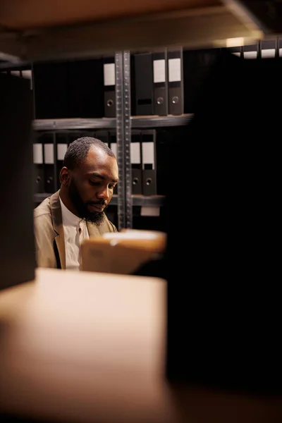 执法专业人员在黑暗的办公室工作到很晚 坐在满是文件夹的工作场所 集中注意力的非洲裔美国警察侦探在夜间破案 — 图库照片