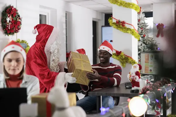非洲裔美国人雇员很高兴收到同事的圣诞礼物在秘密的桑塔年度传统工作在节日装饰办公室 向同事提供圣诞礼物的工作人员 — 图库照片