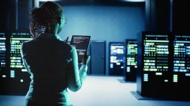 Mühendis sunucu odasında yürüyor ve gelişmiş altyapıları büyük veri bankalarında depoluyor. Karmaşık hesaplama işlemleri yapan veri merkezi platformlarını yükseltmek için tablet üzerinde çalışan işçiler