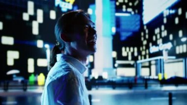 Heyecanlı Asyalı adam gece vakti şehir caddelerinde geziniyor, sevinçten havalara uçuyor, etrafındaki binalara bakıyor. İş adamı iş yerinde terfi ettiği için mutlu.