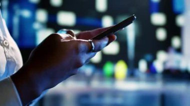 Şehir ortamında bir kadının arkadaşlarıyla konuşmak için gece akıllı telefon kullandığı çok yakın plan bir fotoğraf. Gece vakti sokakta yürürken tanıdıklarıyla iletişim kuran kişi