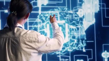 İnsan beyni simülasyonunu hesaplayan yapay zeka hologramına bakan Asyalı geliştirici. Yapay Zeka görselleştirmesi ile etkileşen programcı makine öğrenme algoritmalarını gösterir
