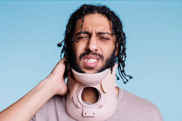 Arab Man Wearing Cervical Collar Grimacing Pain While Touching Neck — Stock Photo, Image