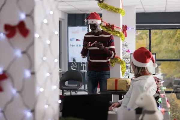 Zaměstnanec Drží Miniaturní Cukrovou Třtinu Ornament Navrhuje Spolupracovníkům Zdobit Vánoční — Stock fotografie