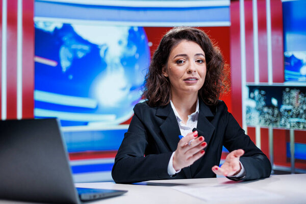 Newscaster discussing on live program, broadcasting latest news reports to create essential television content. Woman journalist working on media segment, reading daily news headlines worldwide.