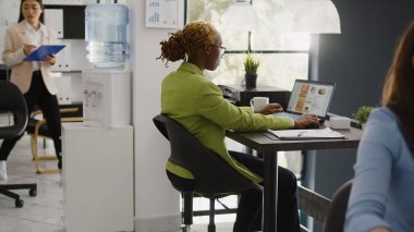 Corporate employee using online analytics to plan investment strategy for profit growth in business office. Young woman working on startup development with laptop, data statistics.
