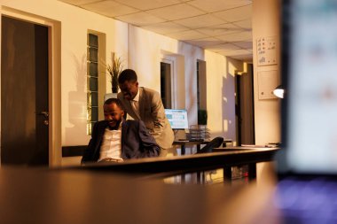 Modern başlangıç ofisinde boş zamanlarında spor yarışlarında masa başı sandalyesine oturan neşeli işçiler. Oyuncu Afro-Amerikan iş adamları eğleniyor, hareketli aktivitelerden zevk alıyor.