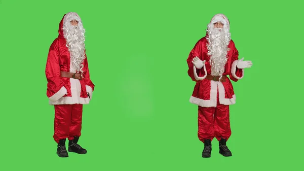 圣诞前夕 圣诞老人在相机上为圣诞前夕的营销 绿屏工作室做广告 圣尼克的化身指向左右来展示一些东西 过冬庆祝的概念 — 图库照片