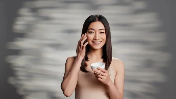 Young Radiant Person Applying Moisturizing Cream Promote Skincare Routine Uplifting — Stok fotoğraf