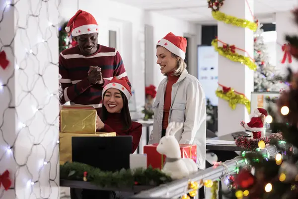 圣诞办公室派对上 快乐的员工在收到圣诞老人的礼物后欢呼起来 在寒假期间 欢乐的工人在装饰过节日的工作空间里享受礼物 — 图库照片