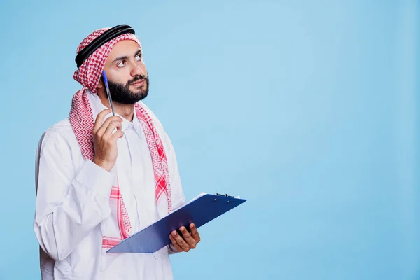 Der Kräftige Mann Traditioneller Muslimischer Kleidung Denkt Nach Während Notizen — Stockfoto