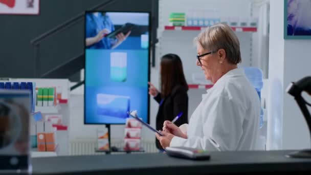 Азиатский Клиент Смотрит Рекламу Фармацевтической Продукции Цифровом Экране Диспансере Приближаясь — стоковое видео