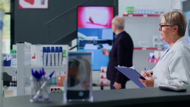 Starsi Klienci Oglądają Reklamę Produktów Farmaceutycznych Ekranie Cyfrowym Aptece Zwracając — Wideo stockowe