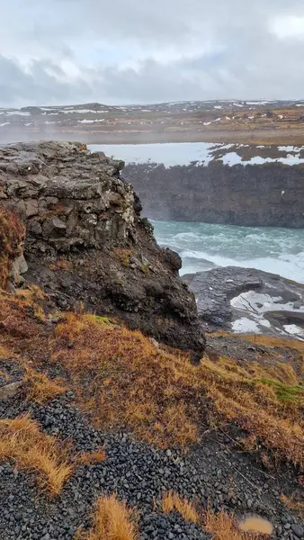 アイスランドのファンタスティックなガルフォス滝 山の端から流れ出る巨大な川 北の荒野の自然 雪で覆われたフィールドと崖の下を流れる水流を持つアイスランドの風景 — ストック写真
