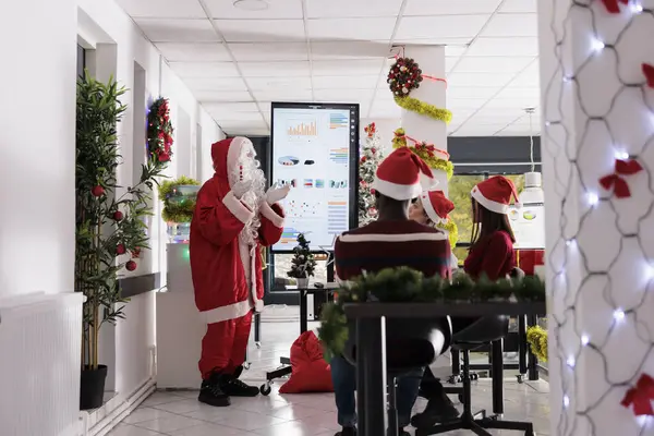 经理打扮成圣诞老人 在寒假期间与工人们举行公司专题会议 管理层主管处理与团队的商业财务斗争 — 图库照片