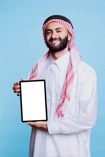 微笑的穆斯林男子展示数字平板与空白的白色屏幕 并以愉快的表情看着相机 快乐的Arab广告主手持空白触摸屏肖像 — 图库照片