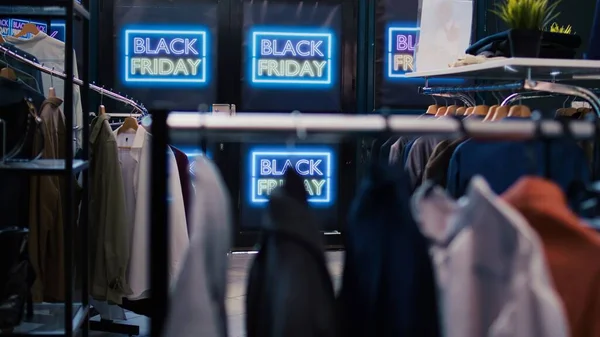 Black friday best deals on products. Modern clothing items being on promotion, various brands merchandise. Empty shopping center filled with red price tags, november discount offers.