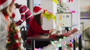 Noel Baba şapkası takan bir çalışan Noel süslü ofiste çalışıyor ve iş arkadaşından yardım istiyor. Personel çalışanı, Xmas 'taki meslektaşıyla birlikte iş gelirlerini inceliyor.