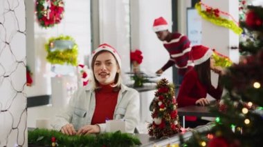 Noel dekore ofisindeki neşeli kadının portresi sosyal medya kanalı pazarlama vlog 'una katılıyor, izleyicileri selamlıyor ve gülüyor, Noel şenliği havasında eğleniyor.