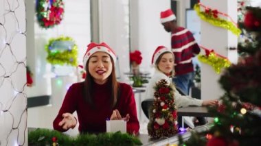 Noel süslemeli çalışma alanında Asyalı müdürün portresi sosyal medya kanalı için vlog hazırlıyor, şirket değerlerinden bahsediyor, kış tatili sezonunda yeni çalışanlar çekmeye çalışıyor.