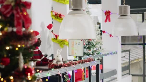 Африканський Американський Працівник Капелюсі Санта Який Працює Різдвяному Прикрашеному Офісі — стокове відео
